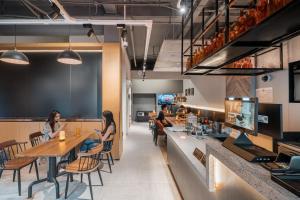 people sitting at a bar in a restaurant at Joy Hongqiao Airport and Railway Hotel in Shanghai