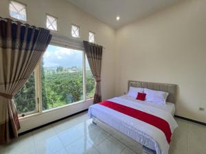 a bedroom with a bed and a large window at Reddoorz Near BNS 2 in Tlekung