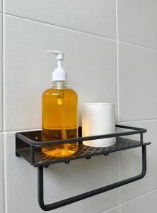 a soap dispenser on a black shelf in a bathroom at Fourteen Homestay in Port Dickson