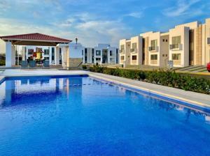 una gran piscina azul con edificios en el fondo en Maravilloso apartamento en privada con alberca en Valente Díaz y La Loma