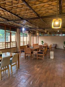 a dining room with wooden tables and chairs at بيت نُزل السلام Bait Salam inn in Al Ḩamrāʼ