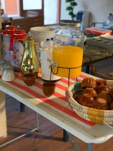 a table with a jar of orange juice and a basket of cookies at بيت نُزل السلام Bait Salam inn in Al Ḩamrāʼ