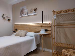 a bedroom with a bed and a wooden headboard at Pensión Cabezas Oviedo in Oviedo