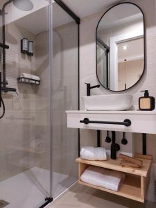 een badkamer met een wastafel en een spiegel bij Pensión Cabezas Oviedo in Oviedo