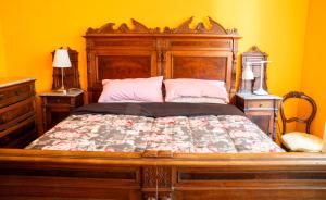 - une chambre avec un lit en bois et 2 oreillers roses dans l'établissement Appartamento Dolce Vita, à Jesi