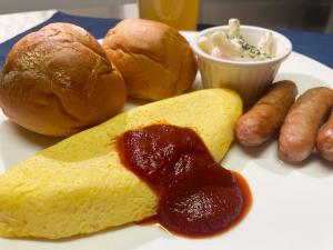 a plate of food with hot dogs and bread and sauce at Xenia Amagasaki in Amagasaki