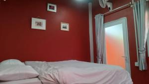1 dormitorio con paredes rojas y 1 cama con espejo en Orkun Jaa Bungalow, en Kampot