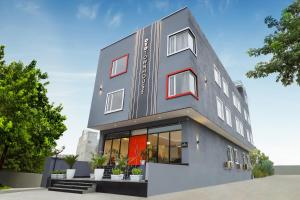 a gray building with red accents at Super Townhouse Golden Avenue Road in Amritsar