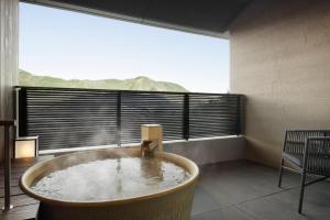 a room with a large window with a large tub at Laforet Hakone Gora Yunosumika in Hakone