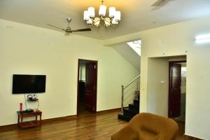 een woonkamer met een plafondventilator en een televisie bij Narayani Resort - Serene resort with private swimming pool in Tiruvannamalai