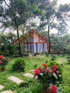 a house in the middle of a yard with flowers at Căn Hana ( Moon Villa Sóc Sơn) in Hanoi