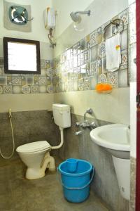 y baño con aseo y lavamanos. en Narayani Resort - Serene resort with private swimming pool en Tiruvannāmalai