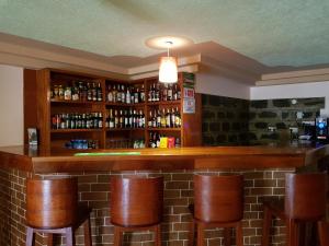 un bar con taburetes marrones en una habitación en Jari Inn Bistro en Ngong