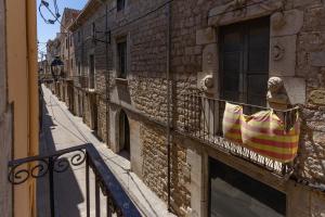 un balcone con bandiera su un edificio di Empordanna, Apartamento con encanto en el corazón del Empordà a Torroella de Montgrí