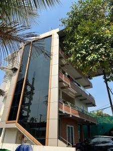 a building with a glass facade with a tree at Kafeel Homes in Ernakulam
