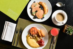two plates of breakfast food and a cup of coffee at The Westin Doha Hotel & Spa in Doha