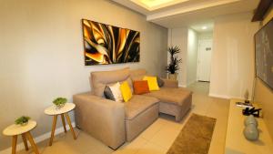 una sala de estar con sofá y una pintura en la pared en 1072 - Apartamento 3 suítes Alto Padrão com SPA na Praia de Bombinhas, en Bombinhas