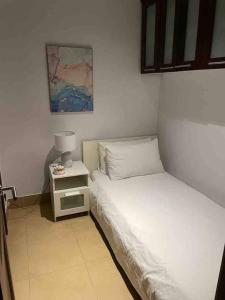 a small bedroom with a bed and a night stand at Three bedroom apartment in Saadiyat district in Abu Dhabi