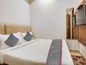 a bedroom with a bed with two pillows and a tv at Hotel Ludhiana Regency in Ludhiana