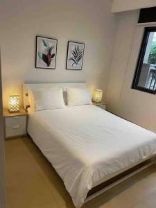 a bedroom with a large white bed with two lamps at Three bedroom apartment in Saadiyat district in Abu Dhabi