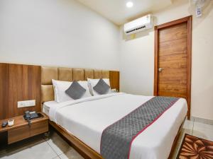 a bedroom with a large bed with a wooden headboard at Hotel Ludhiana Regency in Ludhiana