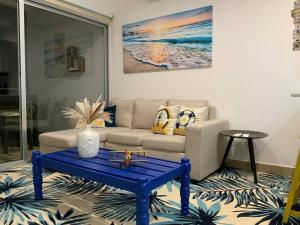 a living room with a couch and a blue coffee table at 2 Bedroom Oceanfront Condo with Wi-Fi, AC and Pool in Parrita