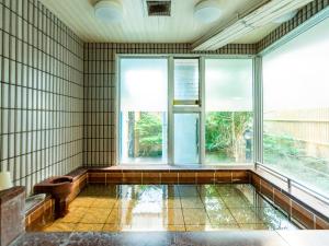 an empty room with a large window and a tub at Asuka Hotel in Karatsu