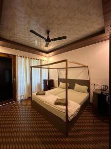 a bedroom with a canopy bed with a fan at Patnem Beach Cottages in Patnem