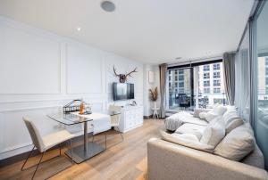 a living room with a couch and a table at Chelsea Harbour Living in London