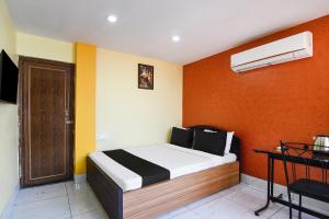 um quarto com uma cama com paredes laranja e amarela em OYO Royal Crown Banquet em Calcutá