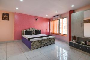 1 dormitorio con 1 cama grande y paredes rosas en OYO Royal Crown Banquet, en Calcuta