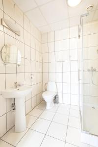 a white bathroom with a toilet and a sink at Motel Te Klimaty in Czeladź