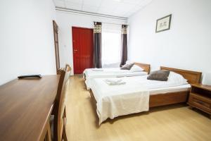two beds in a room with a desk and a desk at Motel Te Klimaty in Czeladź