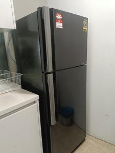 a black refrigerator in a kitchen next to a counter at vortex klcc RR in Kuala Lumpur
