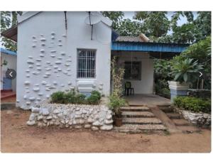 Casa blanca con pared de piedra en Similipal Eco Retreat, Baripada, Odisha, en Bālidiha