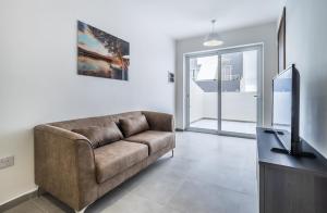 a living room with a couch and a flat screen tv at Penthouse in St. Paul's Bay in St Paul's Bay