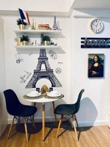 una mesa y 2 sillas en una habitación con la torre Eiffel en Paris Themed Condo in BGC (by The Fort Strip), en Manila