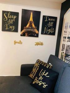 una sala de estar con fotos de la torre Eiffel en la pared en Paris Themed Condo in BGC (by The Fort Strip), en Manila