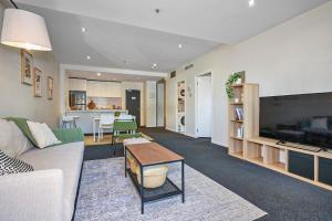 a living room with a couch and a table at Collins Street City Stay - 2 Min to Southern Cross in Melbourne