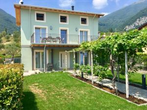 a villa with a view of a house with a yard at Casa con ampio terrazzo, vista lago e giardino in Toscolano Maderno