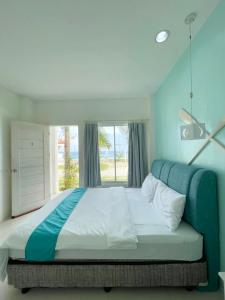 a bedroom with a large bed with a window at Seascape Beach Resort Oslob in Oslob