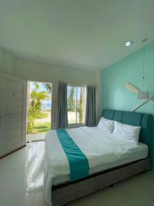 a bedroom with a large bed with a large window at Seascape Beach Resort Oslob in Oslob