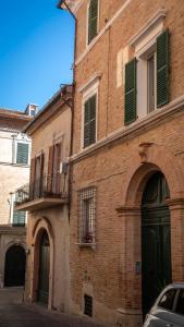 un vieux bâtiment en briques avec une porte et un balcon dans l'établissement Appartamento Dolce Vita, à Jesi