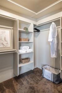 a walk in closet with white shelves and towels at Benchview in Ogden