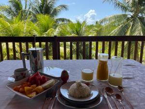 una mesa con un plato de comida y zumo de naranja en Ecolodge Batel Alagoas, en Coruripe