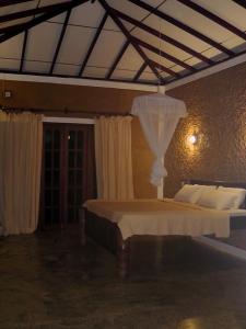 een slaapkamer met een groot bed met een baldakijn bij Manikgoda Tea Paradise in Matugama