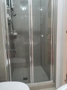 a shower with a glass door in a bathroom at Modern 1BR with balcony and 100mbps wifi in Manila
