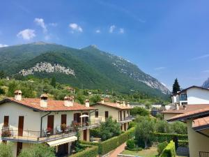 a view of a village with mountains in the background at Casa con ampio terrazzo, vista lago e giardino in Toscolano Maderno