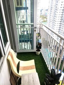 a balcony with a bench and a large window at Modern 1BR with balcony and 100mbps wifi in Manila