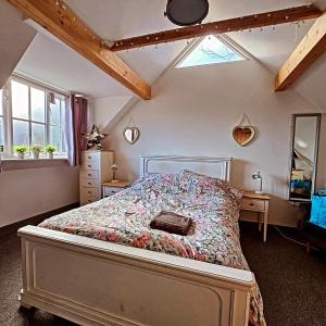 a bedroom with a bed with a floral bedspread at Beach hut seaside cottage in Sheringham
